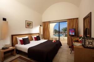 米多恩杰尔巴圣提多海滩酒店的酒店客房设有一张床和一个阳台。