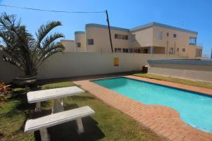 马盖特Manaba Breeze 3的房屋前设有2个长椅的游泳池