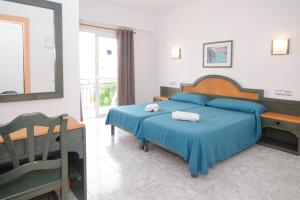 圣安东尼奥罗萨莉娅旅馆的一间卧室配有一张带蓝色床单和镜子的床