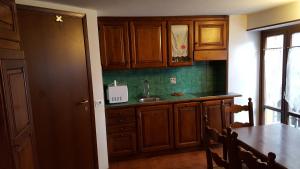 布勒伊-切尔维尼亚Maison Rosalp的厨房配有木制橱柜和带水槽的桌子。