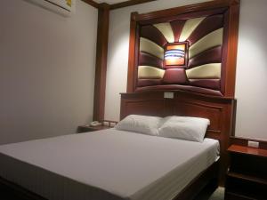 七岩七岩SP公园酒店的一间卧室配有一张带木制床头板的床