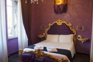 罗马教皇套房酒店的一间卧室配有一张特大号床和紫色墙壁