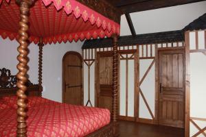 Ardevon小山住宿加早餐旅馆的一间卧室配有一张红色天蓬床