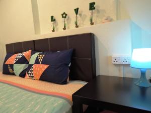 马六甲匹洛胡斯旅馆的一间卧室配有一张带书桌和枕头的床。