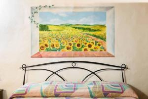 拉波拉诺泰尔梅Armaiolo Relax的一张向日葵的画,上面是一张床