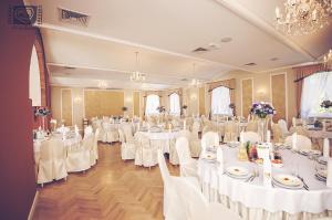 GorzPałac Pawłowice的宴会厅配有白色的桌子和白色的椅子