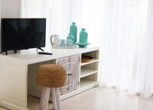 龙目岛库塔和谐公寓的一张桌子上的电视机,椅子