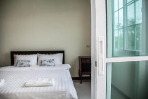 北冲普勒尔恩皮驰公寓式酒店的一间卧室配有一张带白色床单的床和一扇窗户。