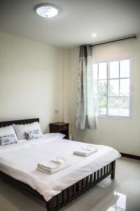 北冲普勒尔恩皮驰公寓式酒店的一间卧室配有一张大床和两条毛巾