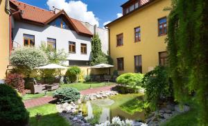 科希策Penzión Hradbová Residence & Spa的一座花园,在一座建筑前设有一个池塘