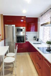 维多利亚-加斯特伊兹Apartamento Vitoria的厨房配有红色橱柜和不锈钢用具