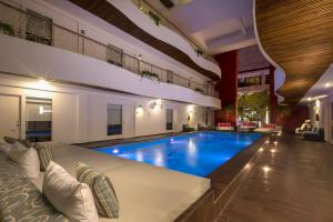 普拉亚卡门In Fashion Hotel & Spa的大型客房的大型游泳池,配有沙发和沙发