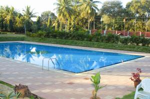 班加罗尔Royal Orchid Resort & Convention Centre, Yelahanka Bangalore的庭院中带秋千的游泳池