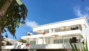 长滩岛日落海滩一室公寓式酒店的白色的建筑,设有窗户,天空蔚蓝