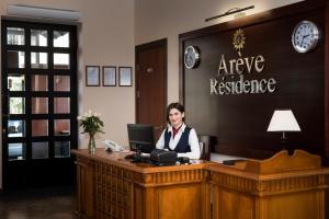 埃里温Arève Résidence Boutique Hotel的坐在办公室桌子上的女人