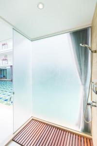 华欣华欣维曼酒店的带淋浴和玻璃墙的浴室