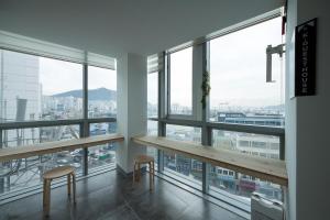 釜山南浦1高级K-旅馆的客房设有桌子、两把椅子和窗户。