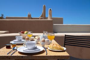 皮尔戈斯沃雷纳画廊套房酒店的阳台上的桌子上摆着早餐食品和饮料