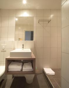 里昂Hotelo Lyon Charité的浴室配有盥洗盆、镜子和毛巾
