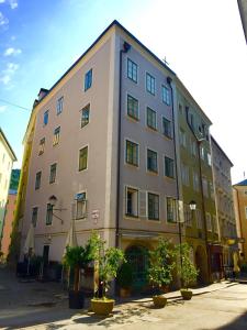 萨尔茨堡Guesthouse Mozart - Apartment House的前面有树木的大建筑