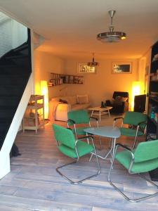 蒂尔堡Gastenverblijf Door de Poort的一间带绿色椅子的客厅和一间卧室