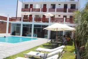 帕拉卡斯修士住宅酒店的酒店设有一个游泳池、遮阳伞和椅子。