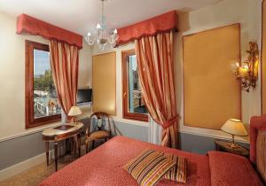 威尼斯阿莱基诺酒店的一间卧室设有红色的床和2个窗户。