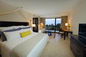 普拉亚伯尼塔村Dreams Playa Bonita All Inclusive的酒店客房设有一张大床和一台电视。