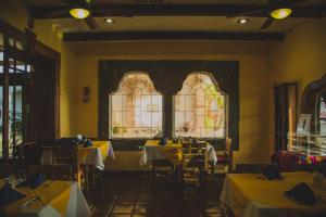 墨西卡利Hotel Cosmos Don Carlos的一间设有桌子和彩色玻璃窗的用餐室