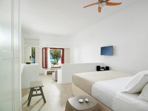 阿波罗尼亚Unique Milos Suites的一间白色卧室,配有床和电视