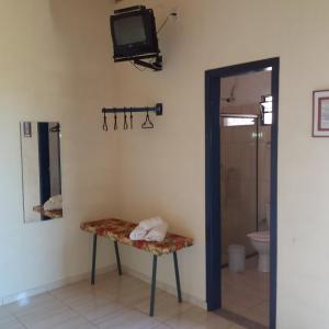 塞拉内格拉Pousada Desfiladeiro da Serra的一间带卫生间的浴室和墙上的电视