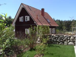科瑟罗Küstenhaus Koserow的黑色的房子,有红色的屋顶和石墙