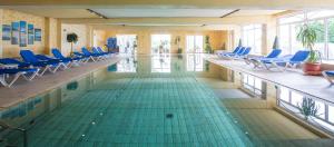 于斯德福瑞斯酒店的一个带蓝色椅子的游泳池和一个游泳池
