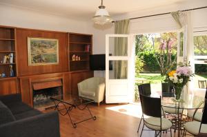 巴塞罗那蒂比达博公寓酒店的客厅设有壁炉、桌子和椅子