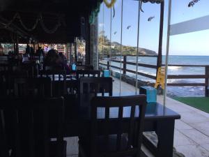 GhaziveranAphrodite Beachfront Apartment的一间设有桌椅的海洋餐厅