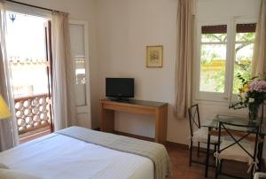 巴塞罗那蒂比达博公寓酒店的一间卧室配有一张床和一张书桌及电视