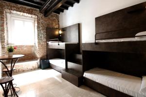 罗马New Generation Hostel Rome Center的客房设有两张双层床和一张桌子。