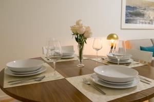 波尔图西蒙宾客公寓的一张木桌,上面有盘子和玻璃杯,上面有鲜花
