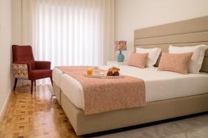 波尔图西蒙宾客公寓的一间卧室配有一张大床和一把椅子