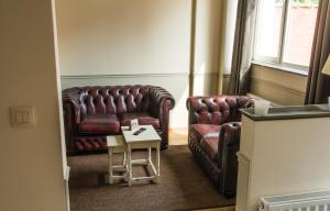 蒙斯圣乔治公寓式酒店的客厅配有两张真皮座椅和一张桌子