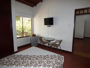 巴耶杜帕尔米萨乐巴耶杜帕尔旅馆的一间卧室配有一张床、一张桌子和一个窗户。