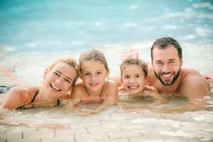 巴德瓦尔特斯多夫H2O Hotel-Therme-Resort, für Familien mit Kindern的游泳池里的一个家庭