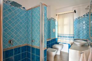 包内伊亚纳斯别墅的蓝色瓷砖浴室设有卫生间和水槽