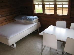 Diernæs魏凯街露营及小屋酒店的一间设有两张床和一张桌子及椅子的房间