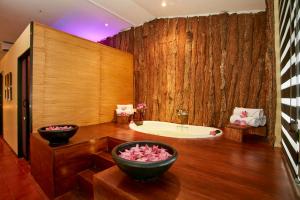 蒂瑟默哈拉默埃克霍蒂萨游猎酒店的带浴缸的浴室和大型木墙