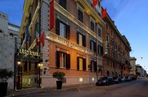 罗马Hotel Principessa Isabella的城市街道上的酒店大楼,外面有汽车停放