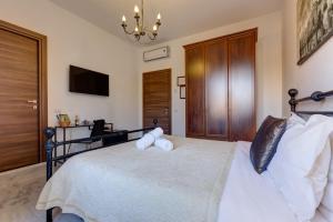 罗马小罗马套房酒店的卧室配有带白色枕头和吊灯的床。