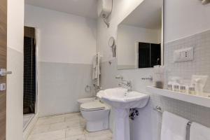 罗马小罗马套房酒店的白色的浴室设有卫生间和水槽。