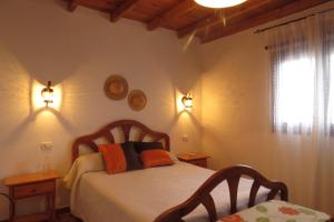 特尔德Casa La Lomada的一间卧室配有一张带两把椅子的床和一扇窗户