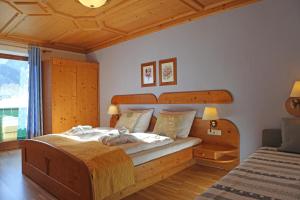 格绍Mühlradl Apartments Gosau的一间卧室配有一张大床和木制床头板